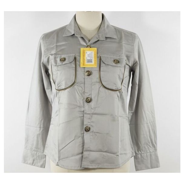 Light gray button-up shirt with long sleeves, flap pockets, and curved zipper trim displayed on a mannequin.