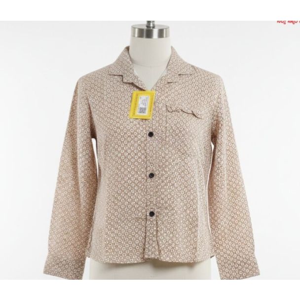 Beige cotton button-up shirt with all-over small circular print on a mannequin.