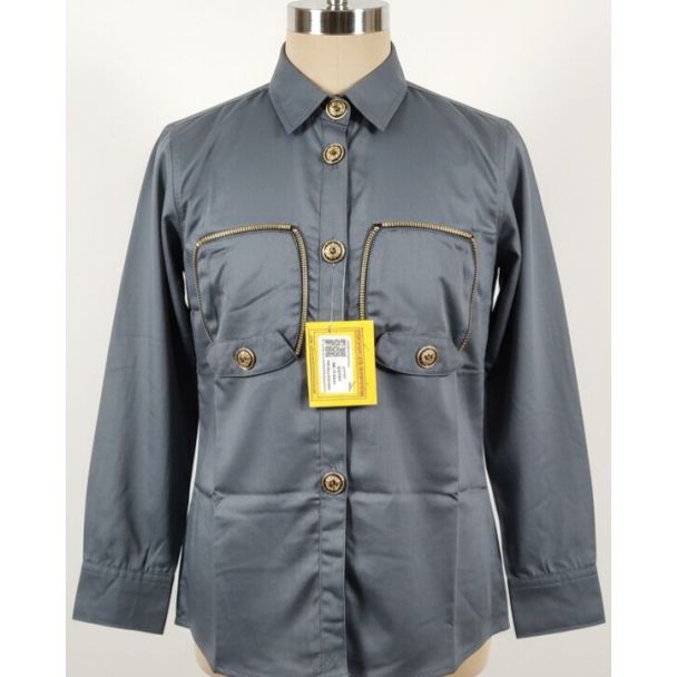 Gray shirt with collar, long sleeves, chest pockets with zippers, and gold buttons on a mannequin.