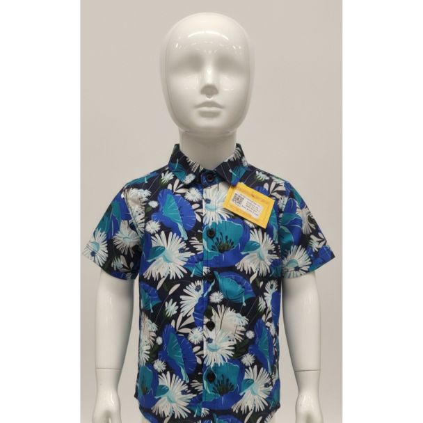 White mannequin wearing a dark blue boys' short sleeve shirt with bright blue and white tropical print.